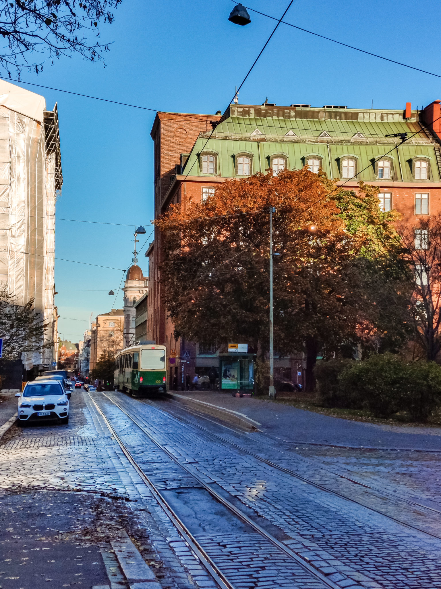 Katu Helsingissä. Ruskaa ja vanhoja rakennuksia, sekä raitiovaunu.
